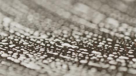 macro view of soap suds bubbling on dark table