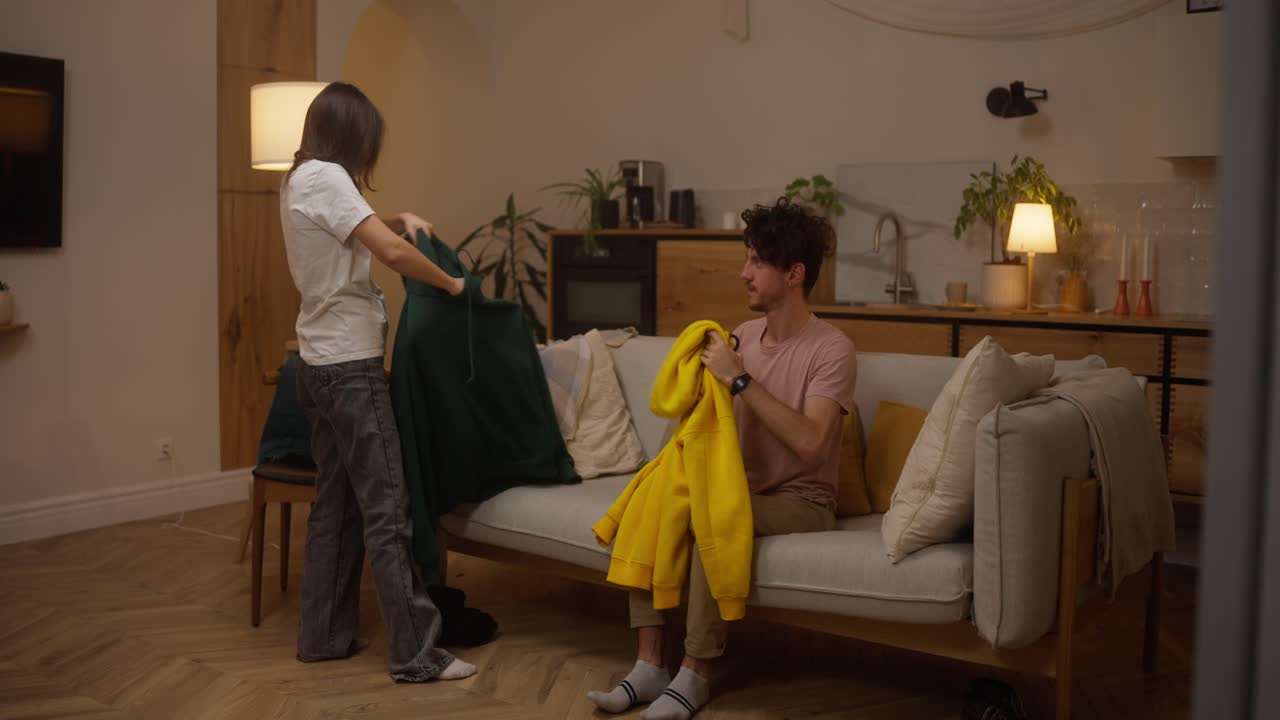 Casal compartilhando uma jaqueta na sala de estar