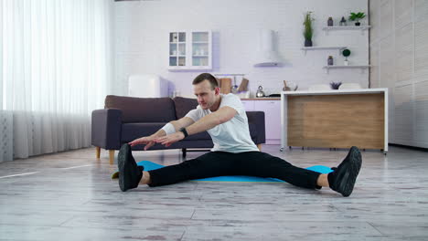 young athletic healthy male training indoors. strong man on quarantine working out in home.