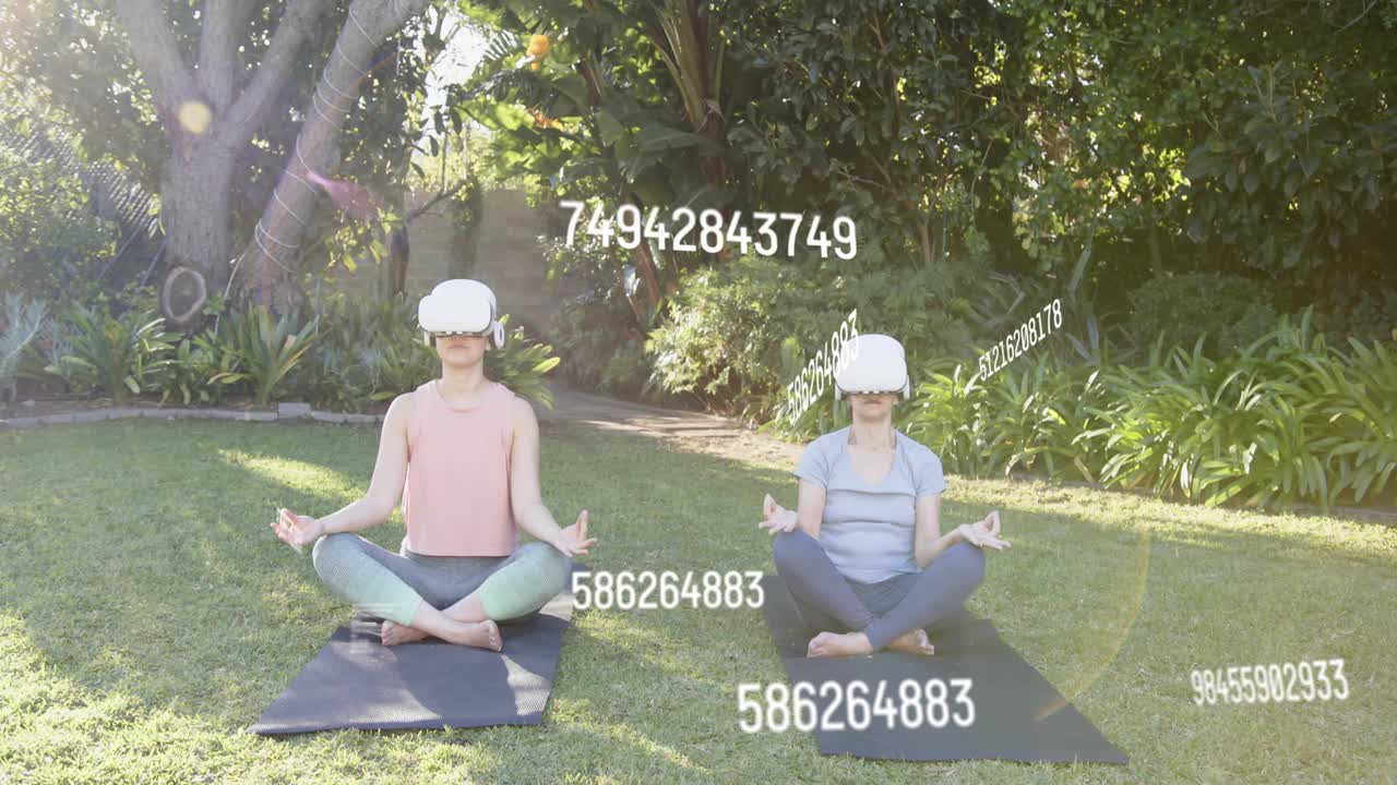 Two women VR-led, cross-legged on mats in yard, raising arms as data-overlays guiding meditation