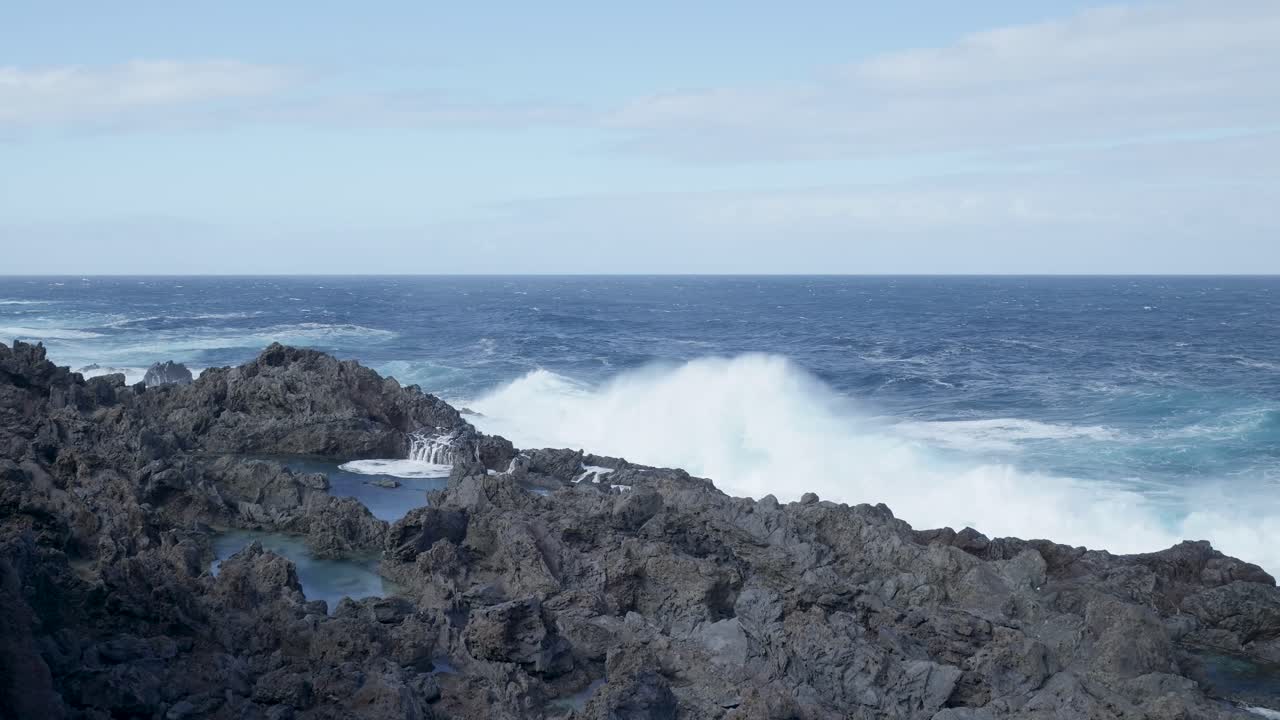 Potentes olas del océano rompiendo en una costa rocosa