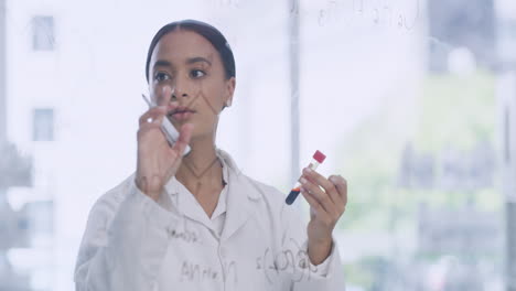 female scientists writing formula on a clear glass