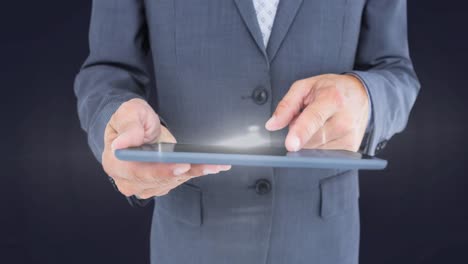 animation of glowing spot of light over tablet screen held by businessman on grey background