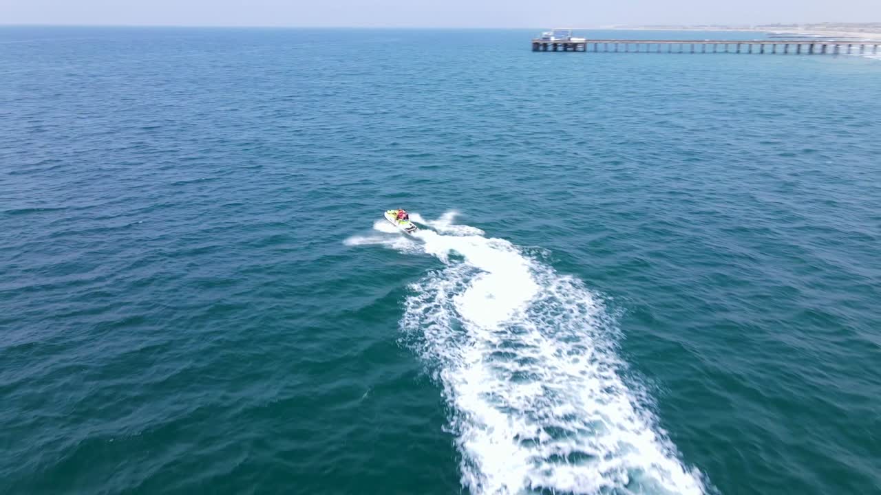 도크에서 멀리 제트 스키를 타는 남자의 훌륭한 공중 샷