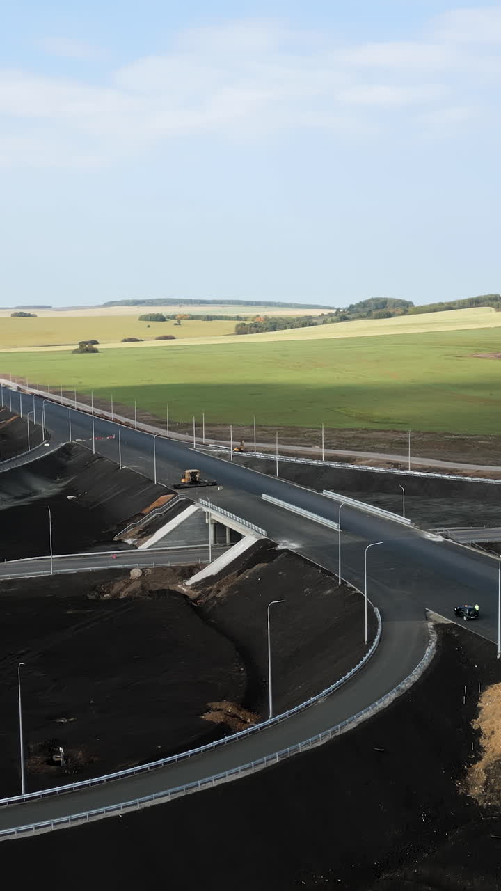 Road construction with green fields in the background