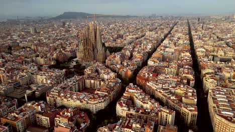 una vista aérea cinematográfica de las torres de la sagrada familia desde todos los ángulos, las calles de cataluña, así como el horizonte de edificios altos y bajos