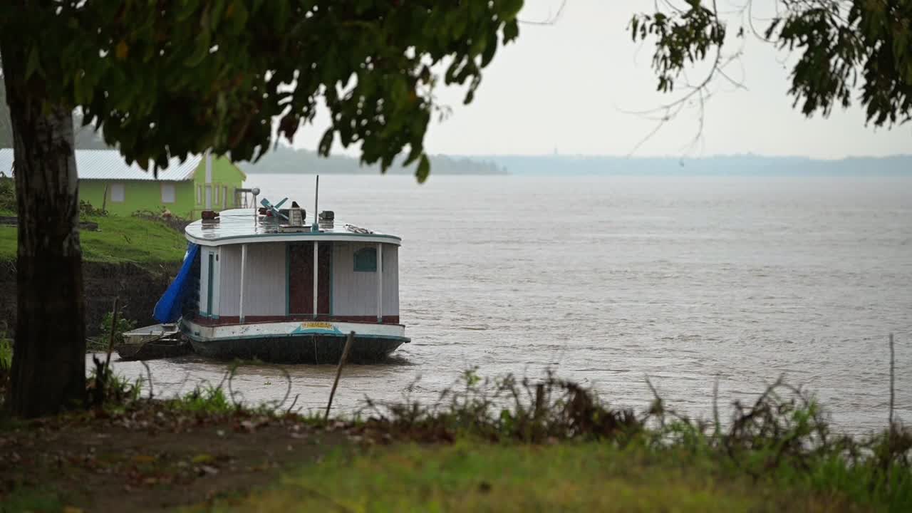 Slow-motion view of a boat docked on the riverbank in the Amazon rainforest