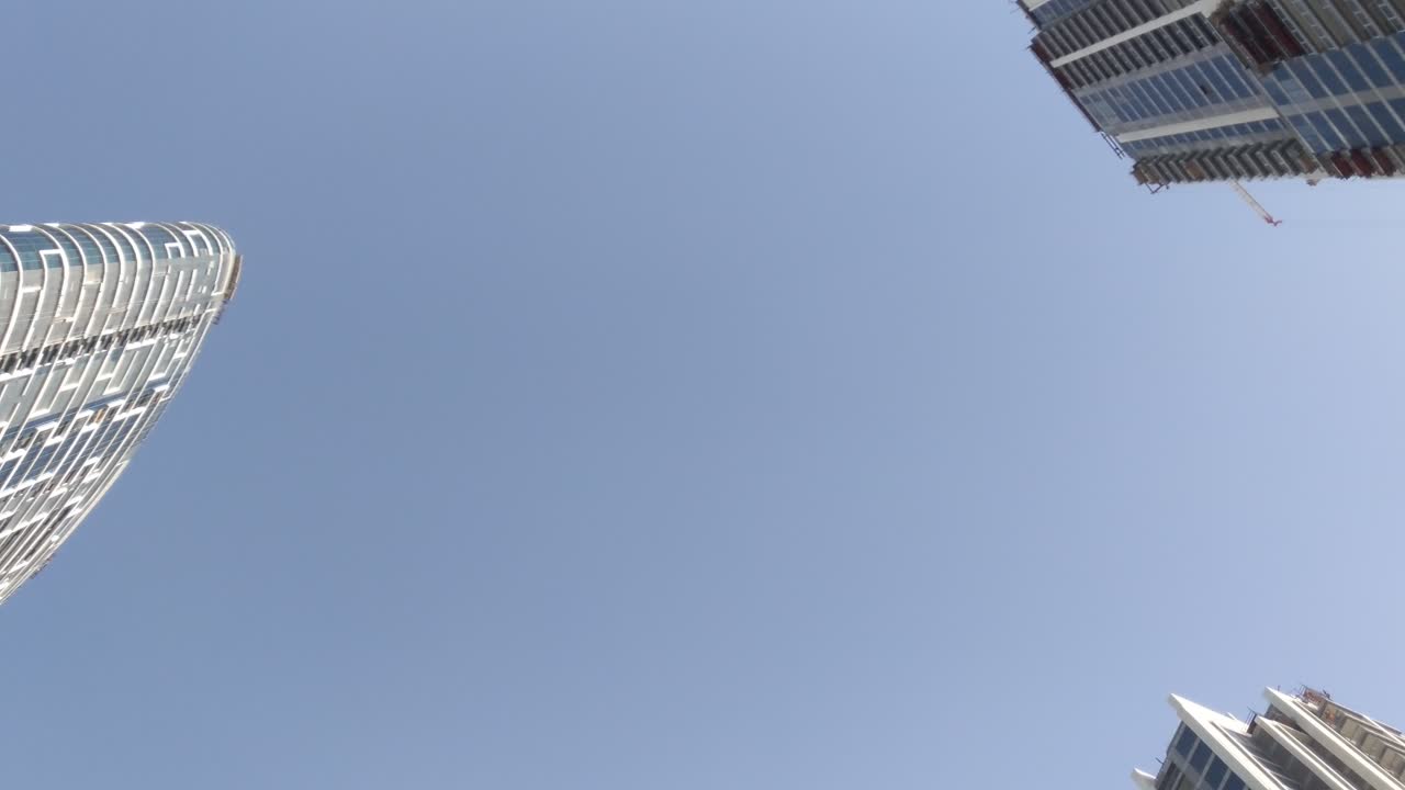 un cielo azul claro con solo la parte superior de los edificios altos en el puerto deportivo de dubai