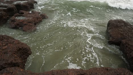 Las-Olas-Rompen-Contra-Una-Costa-Rocosa-En-Un-Día-Nublado,-Creando-Una-Interacción-Dinámica-Entre-El-Agua-Y-Las-Rocas-Escarpadas.