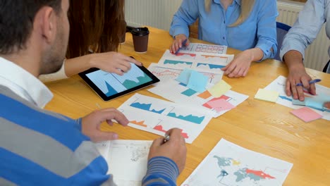 business team meeting brainstorming sharing new ideas diverse team involved in teamwork in trendy brick office space steadicam shot across boardroom table shared work space