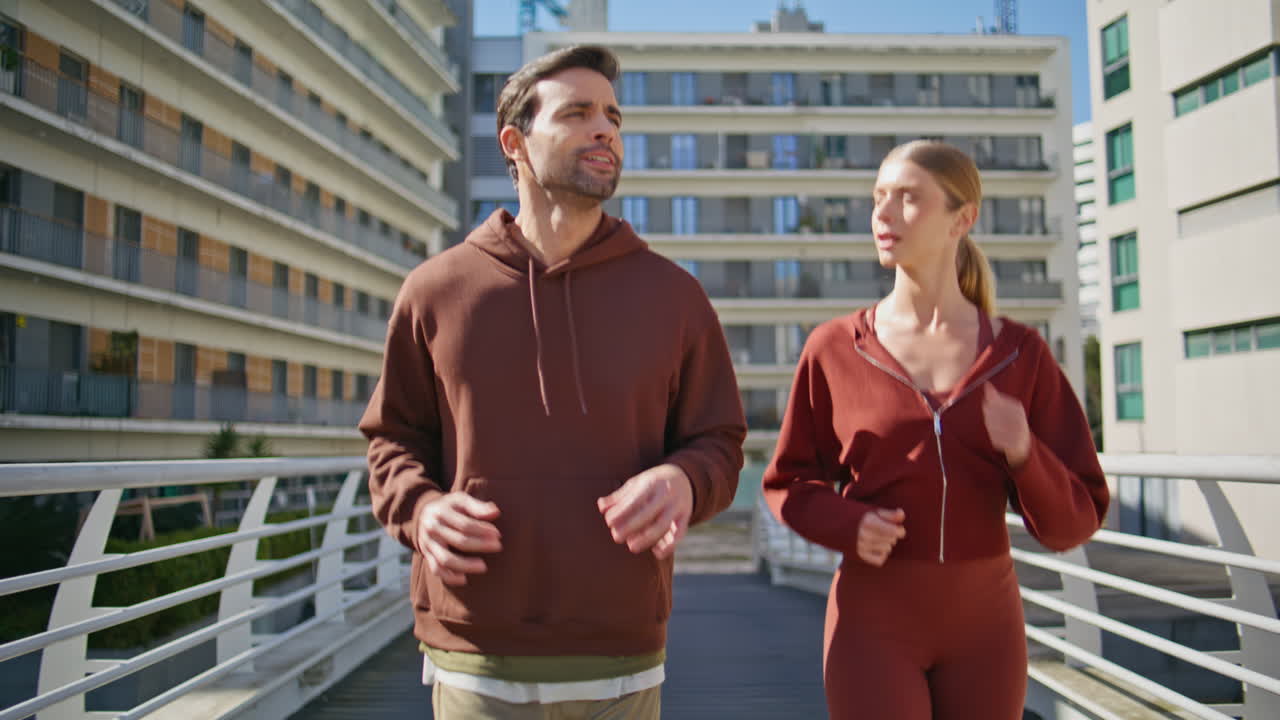 Couple jogging together city street. Active man woman talking during workout