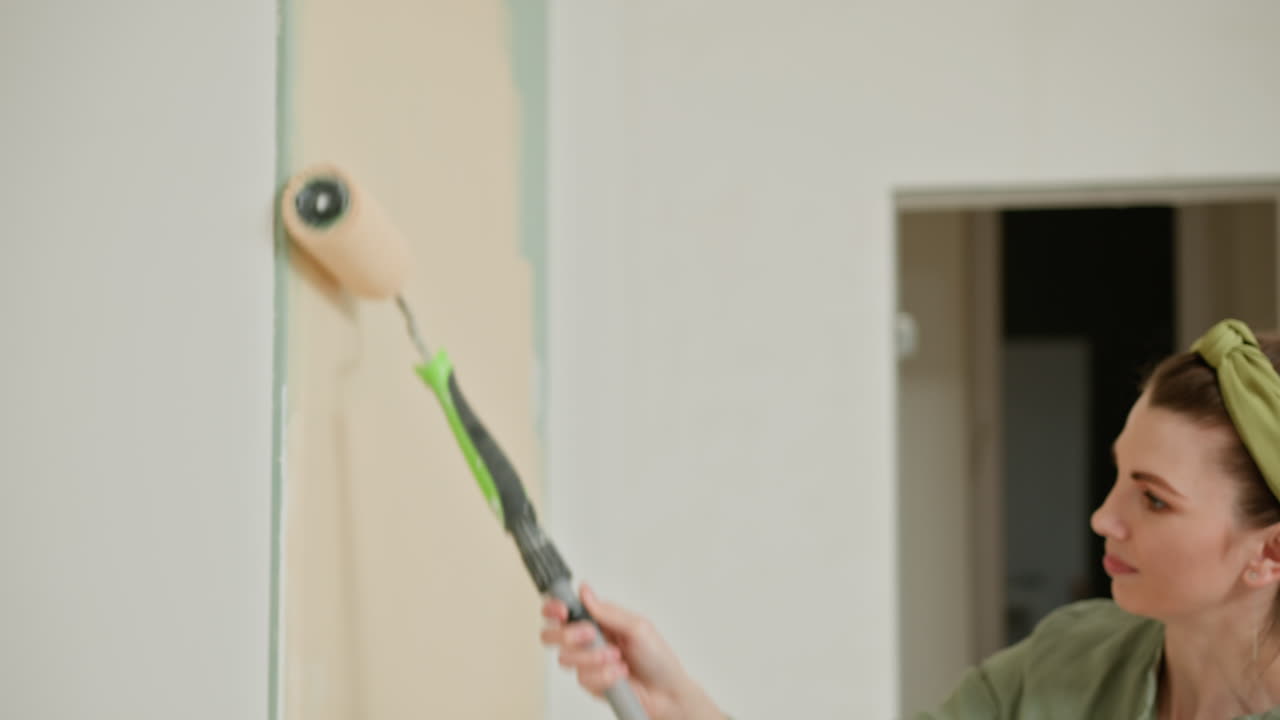 Una mujer pintando una pared.