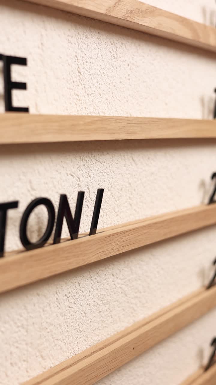 Person placing letters on a wooden wall calendar