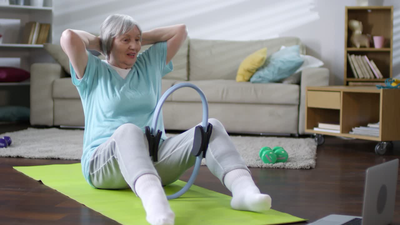 Senior Woman Working Out with Pilates Resistance Ring at Home