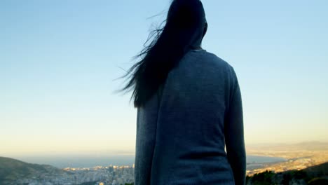 woman standing with arms outstretched on top of the mountain 4k