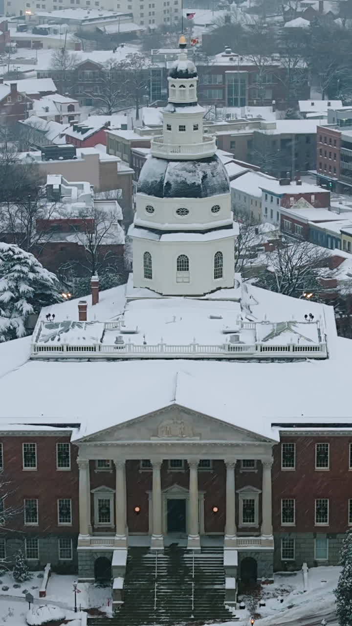 Snow Falling On Maryland State House During Winter In Annapolis, Maryland, USA. - aerial vertical shot