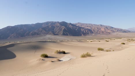 view over mesquite flat sand dunes in death valley national park with mountains in the background in slow motion