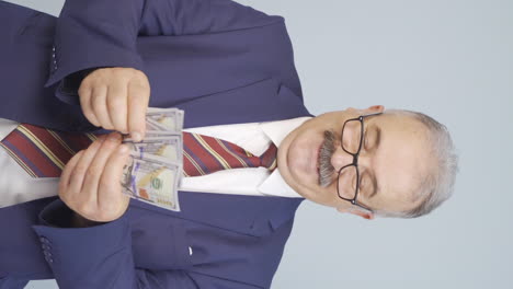 vertical video of rich old businessman counting money.