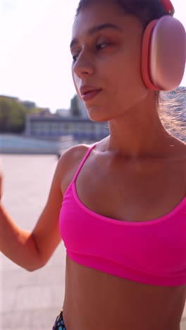 young woman exercising outdoors with headphones