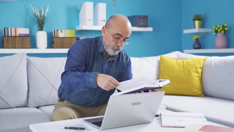 Teacher,-professor-old-man-doing-research-by-looking-at-books.