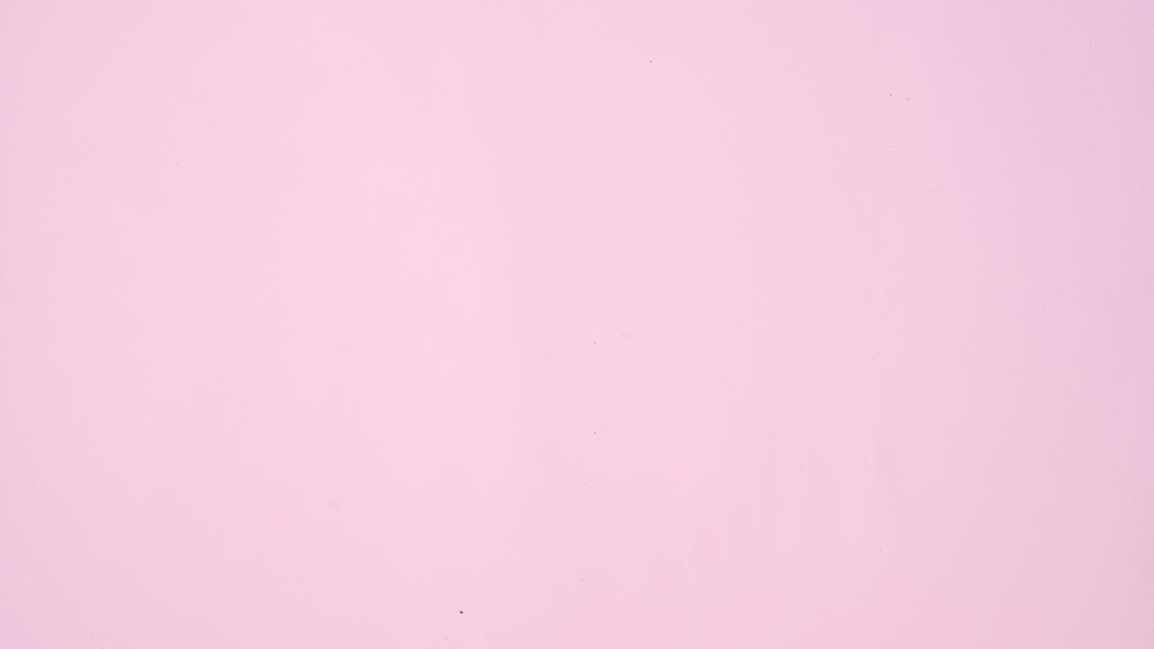 Fresh organic fruits and vegetables comes out from straw shopping bag on pastel pink background. Stop motion flat lay