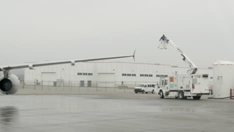 airport ground crew preparing airplane in the rain