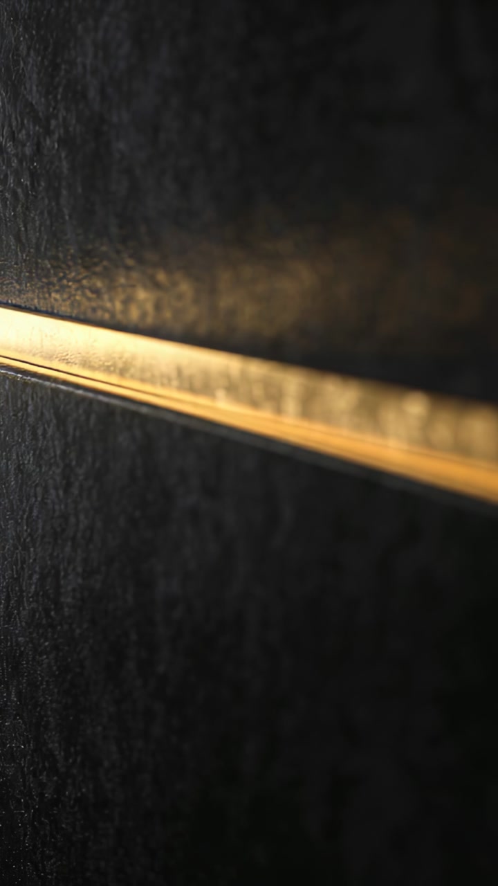Vertical video: Glowing metal trim sliding across matte panel in hall, outside light shifting