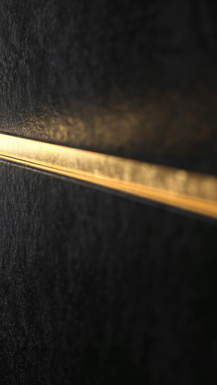 Vertical video: Glowing metal trim sliding across matte panel in hall, outside light shifting