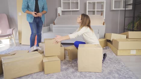 una joven pareja trae cajas a un nuevo apartamento y se ponen a trabajar.