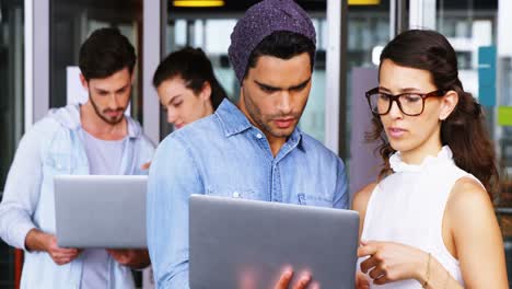 Executives-discussing-over-laptop