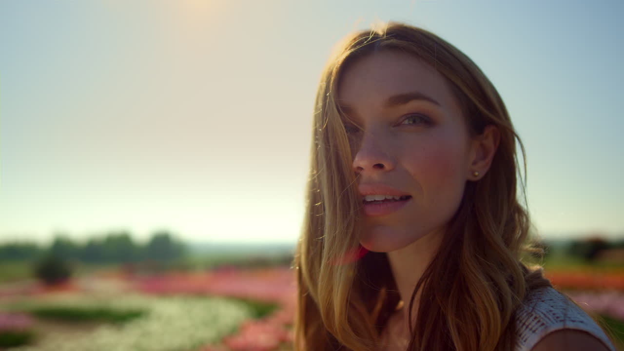 Portrett av vakker jente som smiler mot blå himmel. Nærbilde av smilende kvinne.