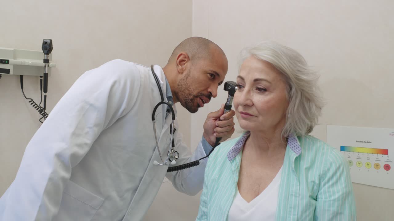 Doctor examining patient with otoscope