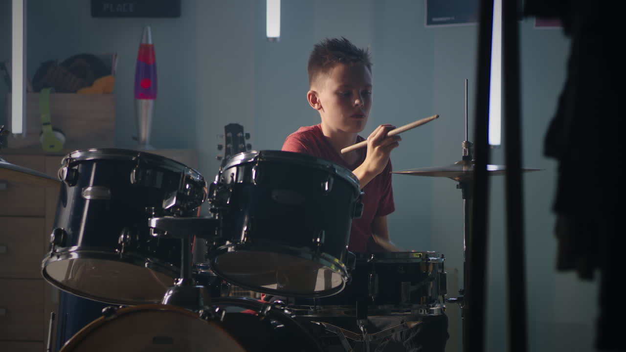 Teen Drummer Practicing at Home serious Teenager with Drumsticks Playing Drums and Cymbals during Music Session at Home