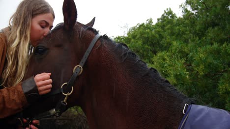 mujer besando a un caballo en una valla de madera en el rancho 4k