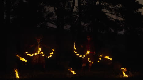 fire dancers at night in a forest