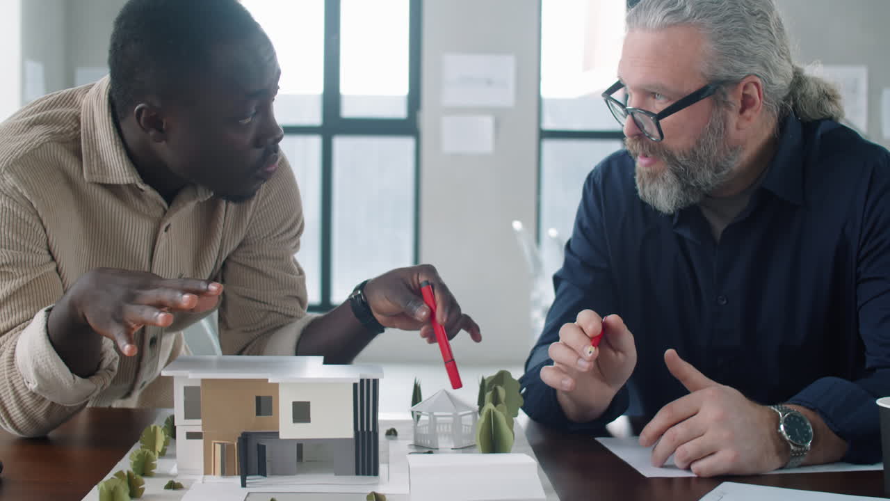 Multiethnic Male Architects Discussing Building Model