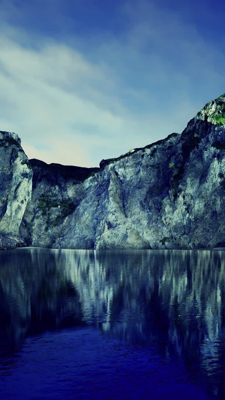 Majestic cliffs reflect in serene waters under a stunning twilight sky