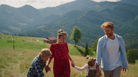 positive familie täuscht die natur auf dem gipfel des hügels. paar amüsiert sich mit kindern.