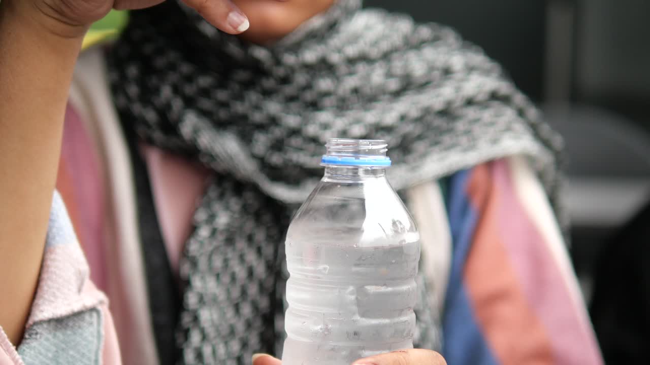mujer bebiendo agua de botella en un coche