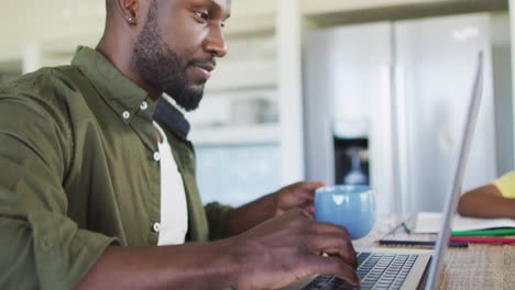 Afroamerikanischer-Vater-Und-Sohn-Machen-Hausaufgaben-Und-Benutzen-Gemeinsam-Einen-Laptop