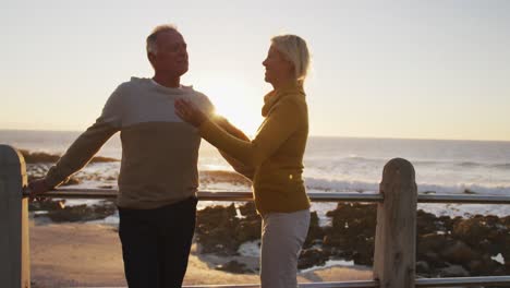 senior couple standing in front of beach