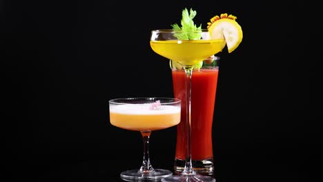 three colorful cocktails elegantly arranged with garnishes, set against a dark backdrop, highlighting vibrant hues and textures