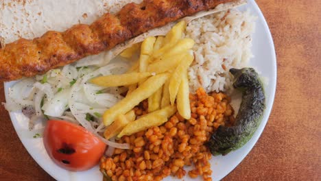turkish kebab platter with rice, fries, and vegetables