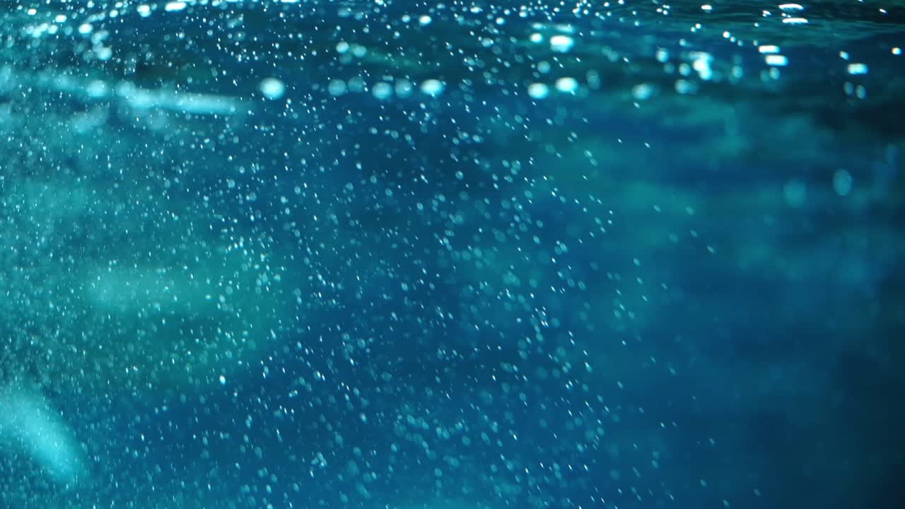 Una scena sottomarina onirica e blu con bolle che salgono in superficie
