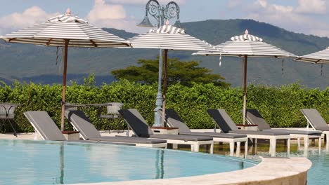 time-lapse of a tranquil poolside with mountain backdrop.