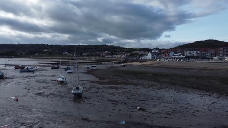 north wales seaside town coastline hotels harbour breakwater aerial view rising pull back