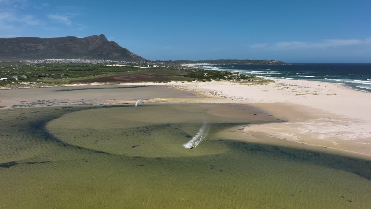 얕은 해변 연못에서 드론 추적 카이트서퍼가 높은 공중에서 거꾸로 뒤집어집니다.