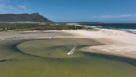 Drohnenverfolgung-Kitesurfer-Im-Flachen-Strandteich-Dreht-Sich-In-Hoher-Luft-Auf-Den-Kopf