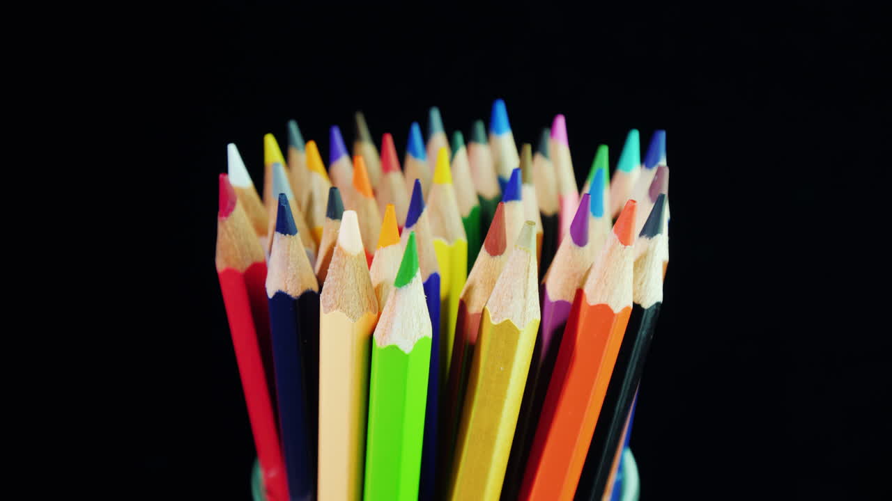 un juego de lápices multicolores sobre un fondo negro