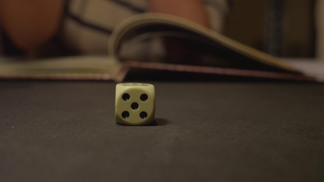 seis dados de cara rodando sobre una mesa negra con un libro de roles en segundo plano.
